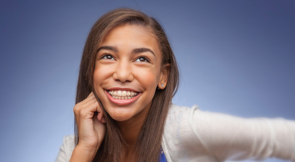 teen girl with clear ceramic braces